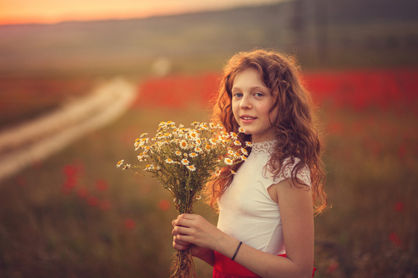 The girl in a poppy field - Фото, изображение