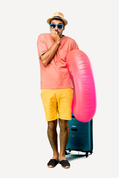 Full body of Man with hat and sunglasses on his summer vacation is a little bit nervous and scared putting hands to mouth on isolated background - Foto, afbeelding