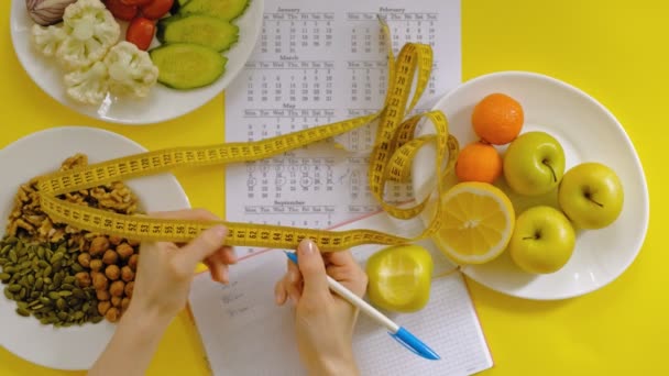 sportkalender, gezond eten, schieten op een gele achtergrond bovenaanzicht - Video