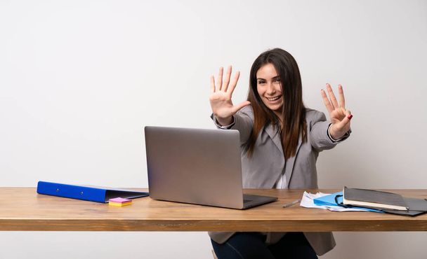 Femme d'affaires dans un bureau comptant huit avec des doigts
 - Photo, image