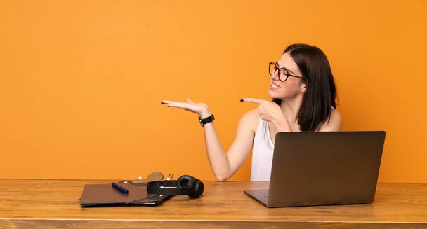 Geschäftsfrau in einem Büro mit einem imaginären Kopierraum auf der Handfläche, um eine Anzeige zu schalten - Foto, Bild
