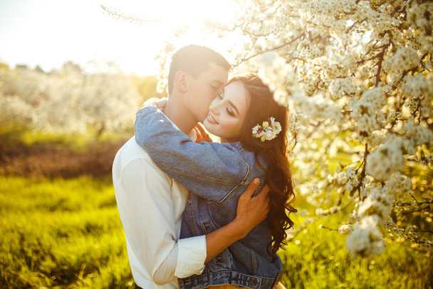Beautiful loving couple in the blooming gardens. Wedding concept. Great sunset light. Lovely newlyweds. - Photo, Image