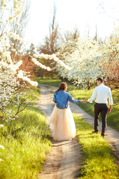 Beautiful loving couple in the blooming gardens. Wedding concept. Great sunset light. Lovely newlyweds. - Foto, Imagem