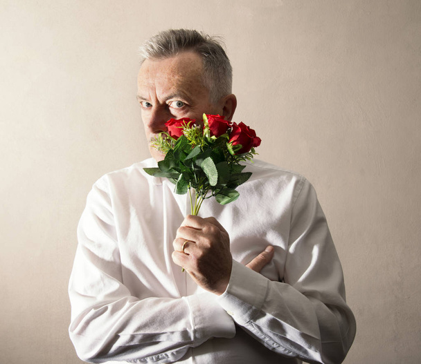man holding a bunch of flowers in his hand - Фото, изображение