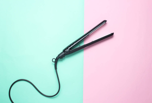 Hair straightener on pastel background. Top view. Minimalism - Photo, Image