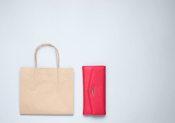 Papieren boodschappentas, rode lederen portemonnee op grijze achtergrond. Top View - Foto, afbeelding