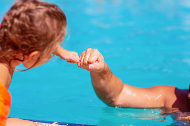 Child learning to swim. Kids in swimming pool - Fotoğraf, Görsel