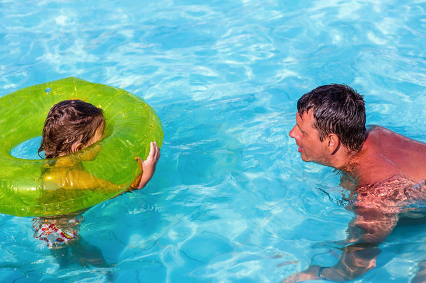 father and daughter playing in swimming pool. Summer funny vacation - 写真・画像