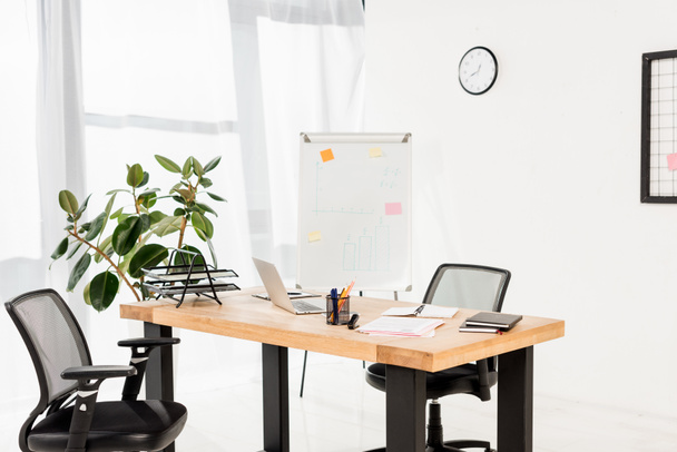 ufficio moderno con lavagna bianca, impianto e laptop sulla scrivania
  - Foto, immagini