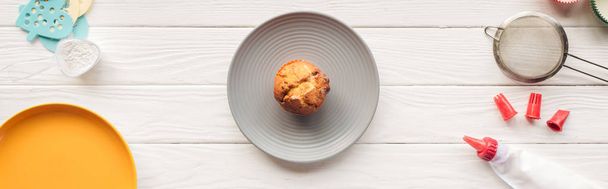 panoramic shot of delicious muffin and baking tools on wooden table - Photo, Image