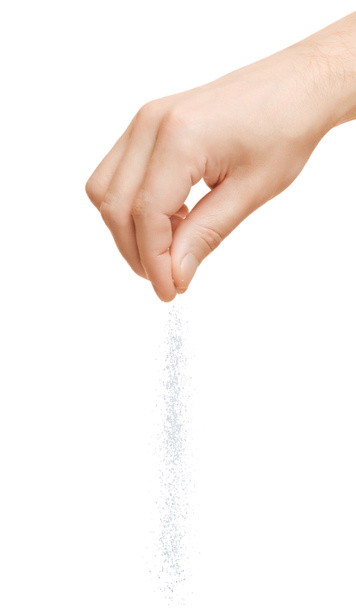 Hand adding salt on a white background - Photo, Image