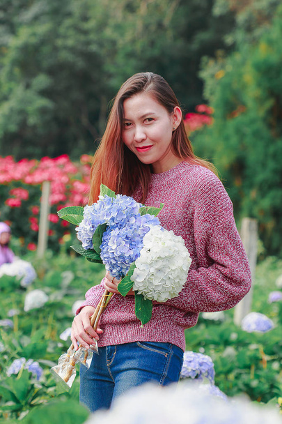 Donne in piedi che tengono fiori ortensie in giardino
 - Foto, immagini