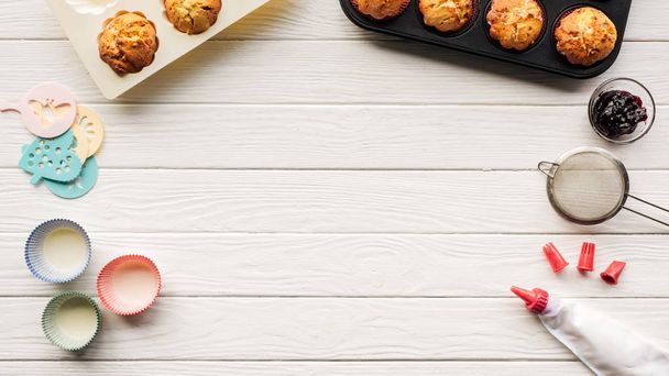 Nejlepší pohled na lahodné muffiny a pečicí nástroje na dřevěném stole s prostorem pro kopírování - Fotografie, Obrázek