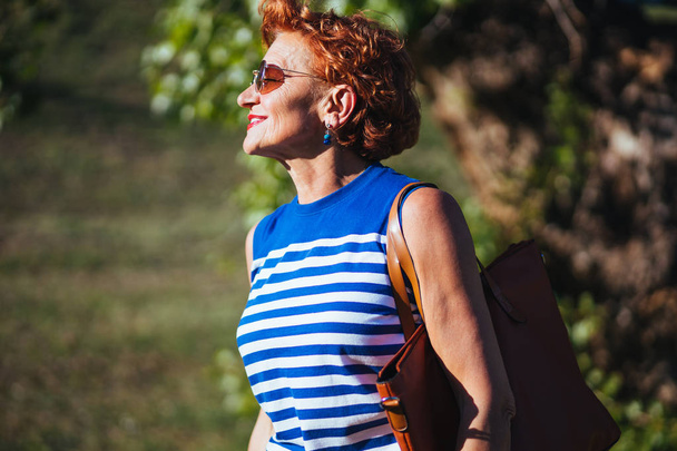 Portrait of a mature woman walking in the park - Photo, Image