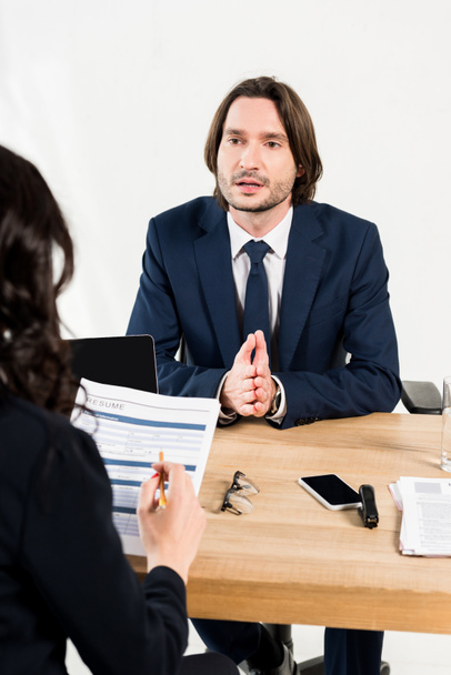 enfoque selectivo de hombre guapo hablando mientras tiene entrevista de trabajo en la oficina
  - Foto, imagen