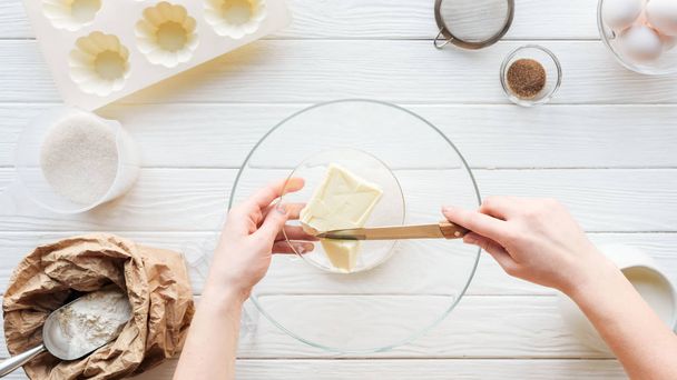 食材を使ったテーブルの上のボウルにバターを切る女性のトリミングビュー - 写真・画像