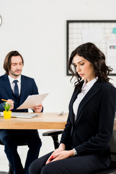 selective focus of upset woman sitting near handsome recruiter  - Photo, Image
