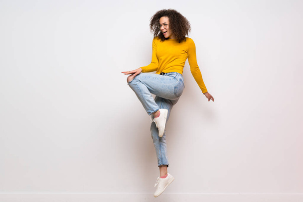 Dominican woman with curly hair jumping over isolated white back - Valokuva, kuva