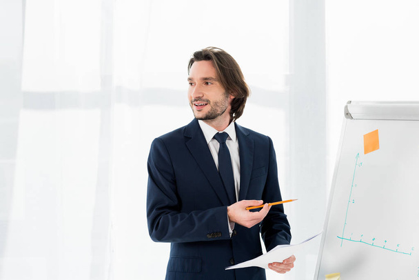 cheerful recruiter holding paper near white board in office  - Foto, Imagen