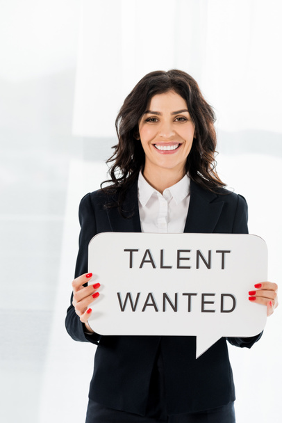 cheerful beautiful recruiter holding speech bubble with talent wanted lettering  - 写真・画像