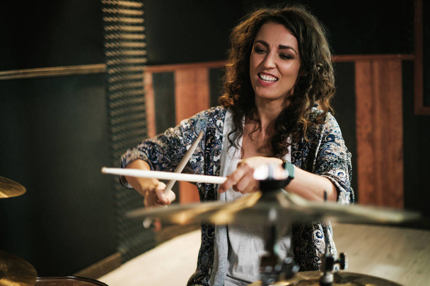 Woman playing drums during music band rehearsal - Fotó, kép