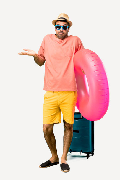 Повнометражний знімок Людини з капелюхом і сонцезахисними окулярами на літніх канікулах робить неважливим і сумнівається жест, піднімаючи плечі і долоні на ізольованому тлі
 - Фото, зображення