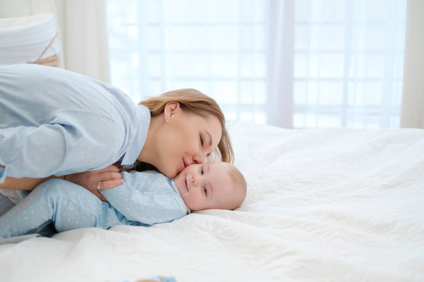 Felice madre di mezza età con il suo bambino in un letto
 - Foto, immagini