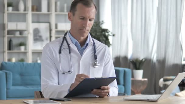 Senior Doctor Reading Medical Documents of Patient - Felvétel, videó