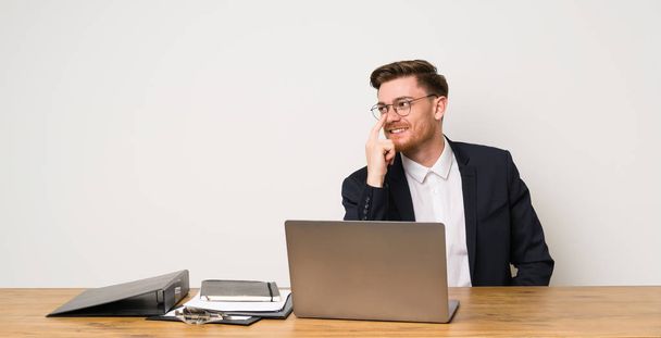 Obchodník v kanceláři s brýlemi a s úsměvem - Fotografie, Obrázek