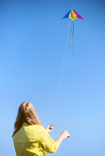 Kite on a rope against the sky. Girl keeps rope. - Zdjęcie, obraz