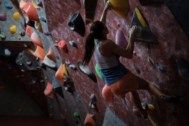 Sportieve vrouw beoefenen in een sportschool boulderen - Foto, afbeelding