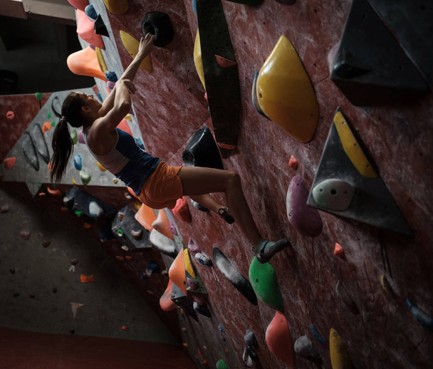 Athletic woman practicing in a bouldering gym - Photo, Image