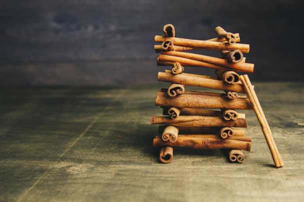 tower of whole sticks of fragrant cinnamon on a wooden rural table. copyspace. composition of seasoning and slide flavoring aromatic spice. close-up. side view, macro - Foto, immagini