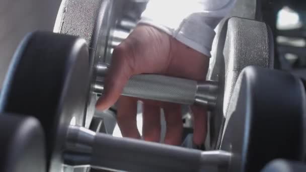 De hand van een getrainde atleet neemt een zware halter. - Video