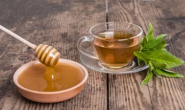 Cup of tea mint honey wooden background - Photo, Image