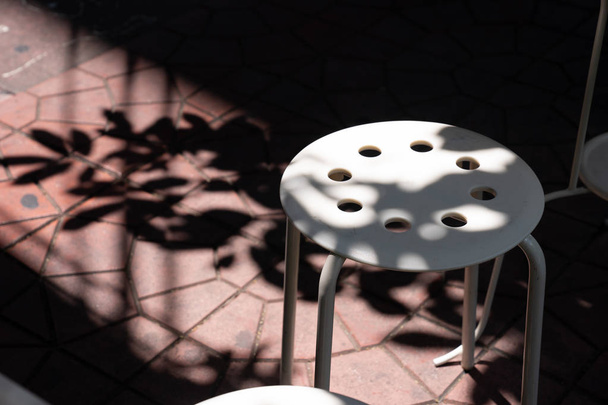 světlo a stín na bílé plastové stolici vně  - Fotografie, Obrázek