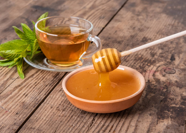 Cup of tea mint honey wooden background - Foto, Bild