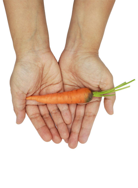 woman hand holding baby carrots isolated on black background. - Foto, immagini