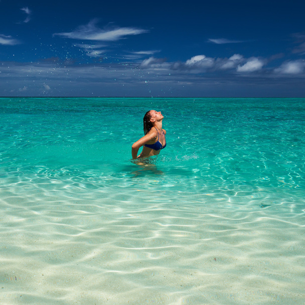 Жінка бризкає воду з волоссям в океані
 - Фото, зображення