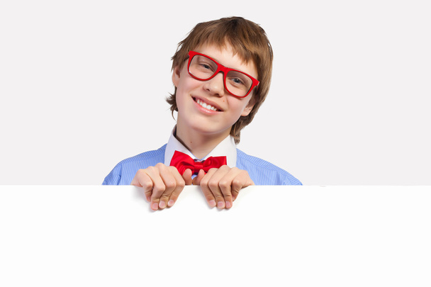Boy in red glasses holding white square - Photo, Image