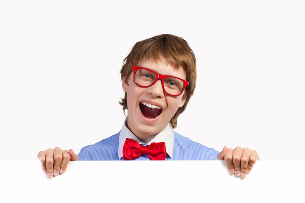 αγόρι σε κόκκινα γυαλιά κρατώντας λευκό τετράγωνο - Φωτογραφία, εικόνα