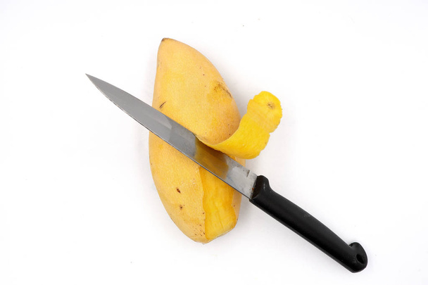mangues mûres, écorce de mangue jaune avec couteau isolé sur bac noir
 - Photo, image