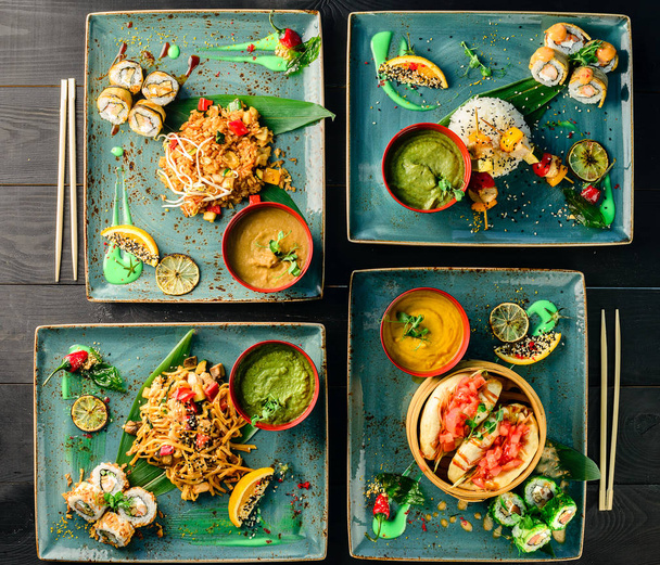asian cuisine, lunch on a tray top view on a black table food background - Фото, изображение