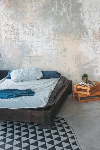 Moderni ekoparvi sisustus makuuhuoneessa, betonilattia, sänky, minimalismi
 - Valokuva, kuva