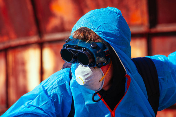 чоловік екологічна маска пожежна упаковка приховує бітмаску захисну загальну синьо-помаранчеву фабрику заводу розливу
 - Фото, зображення