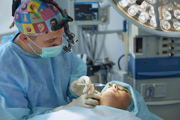 いくつかの医師は、自分の仕事の中に操作テーブルの上に患者を取り巻きます。手術室での作業でチーム外科医 - 写真・画像