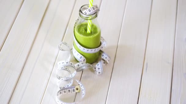 cóctel verde y vegano saludable con cinta de centímetro en la mesa de madera blanca
 - Metraje, vídeo