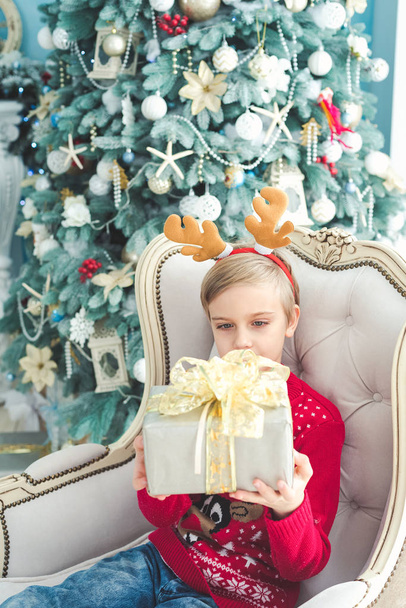 The little girl under the Christmas tree - Zdjęcie, obraz