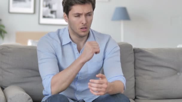 Kanepede otururken hasta genç adam öksürük - Video, Çekim