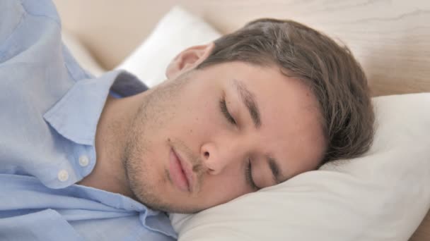 Közelkép a fiatal férfi alszik az ágyban - Felvétel, videó